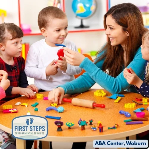 Child playing with educational toy while adult observes during an ABA session at First Steps Developmental Services