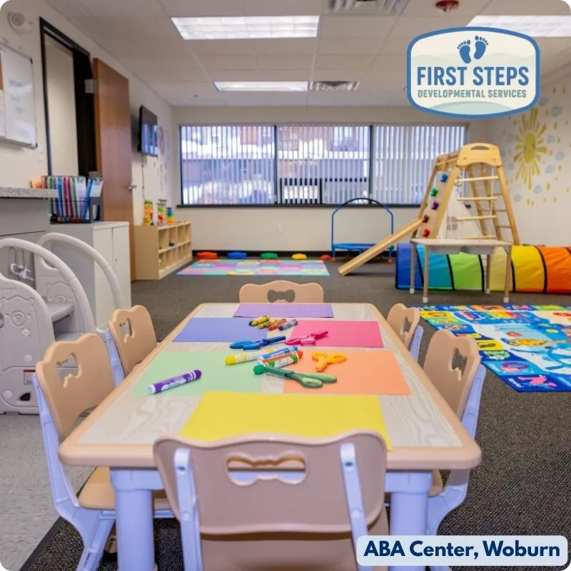 Classroom table with chairs set up for structured learning activities at First Steps ABA Therapy Center in Woburn