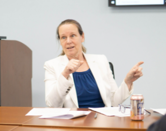 Rachel Thompson, Ph.D., BCBA-D, LABA, Senior Advisor at First Steps Developmental Services, engaged in discussion at a conference table, emphasizing her role in supporting child development and ABA therapy.