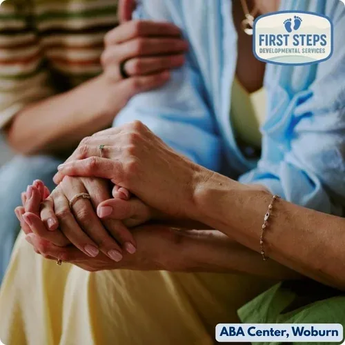 Hands of caregivers supporting each other, symbolizing collaboration and guidance in child development, with First Steps Developmental Services logo.